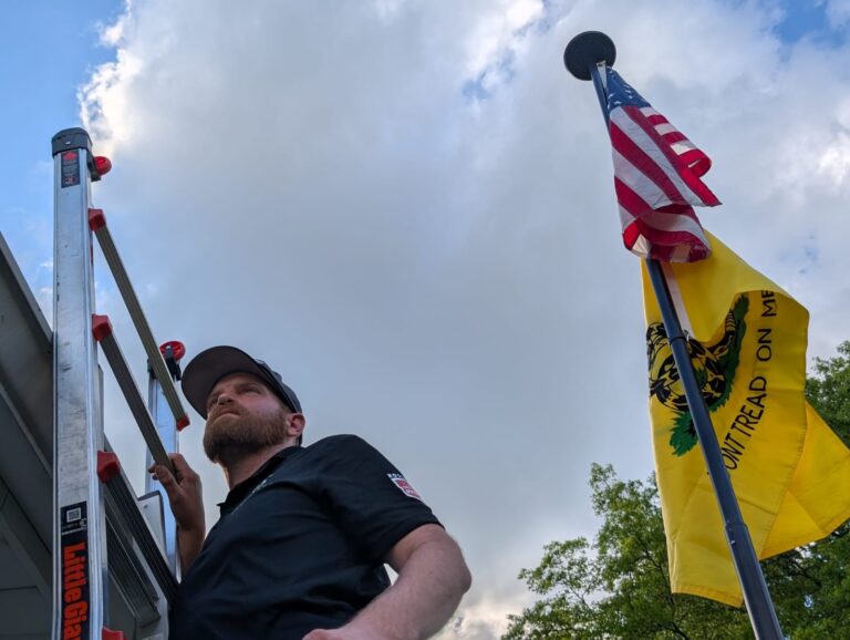 Man on ladder insepcting siding for Brody Allen Exteiors.