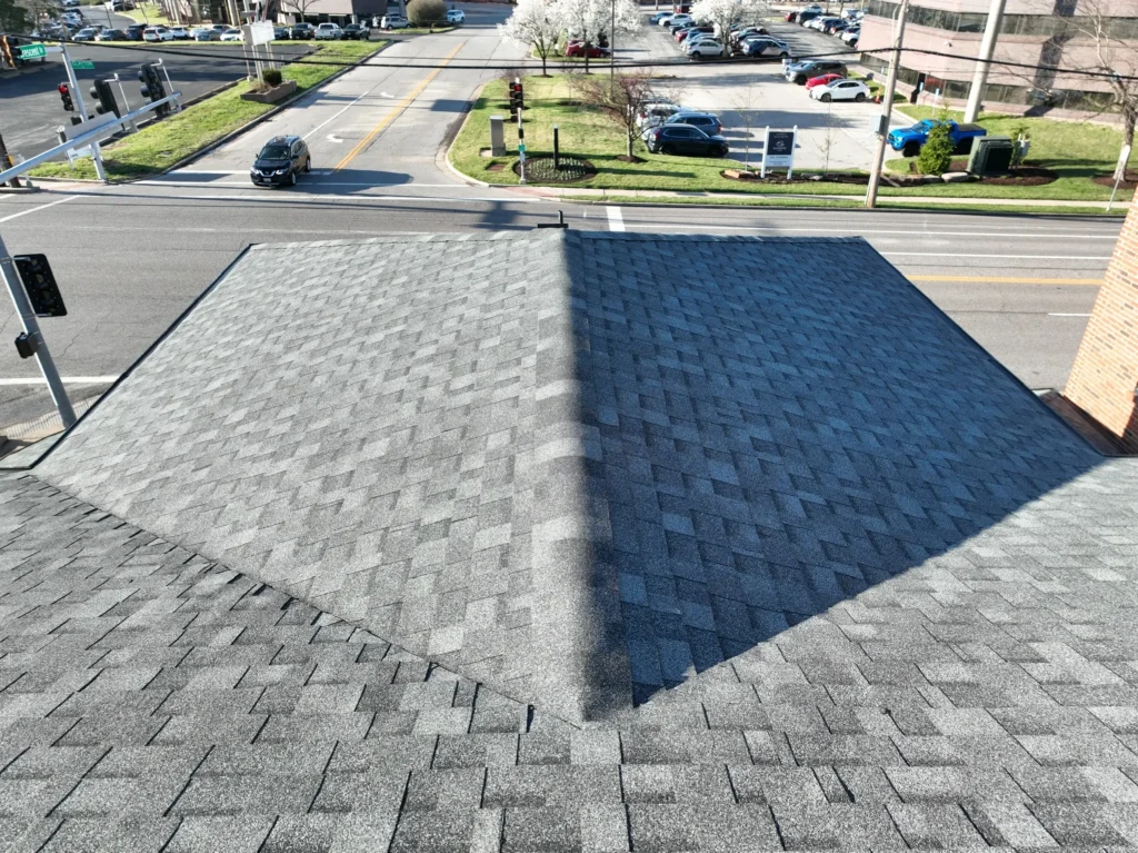 Top-down view of a gray-shingled commercial roof in Clayton, showing detailed roof geometry and surrounding sidewalks.