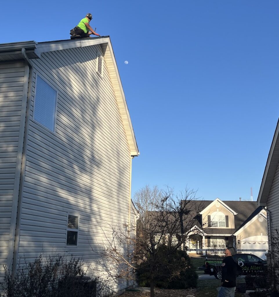 Roofer on roof and truck in background